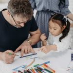 Father and daughter creating art together at home, fostering creativity and connection.